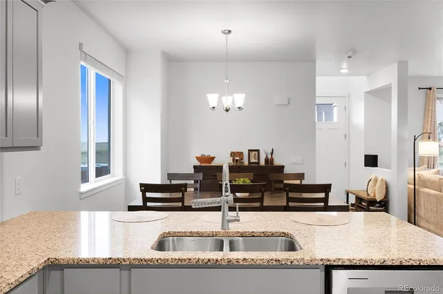 a kitchen with granite countertop a sink and a refrigerator