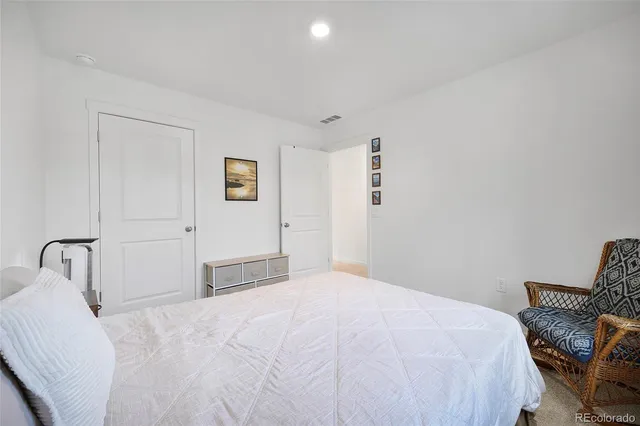 a bedroom with a bed and a chair