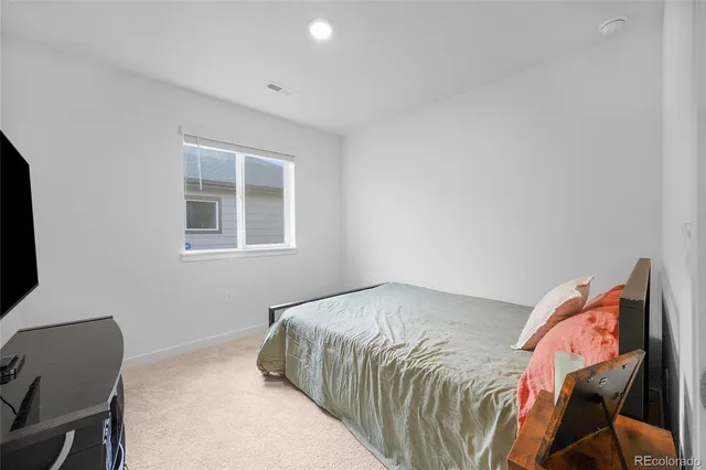 a bedroom with a bed and chair with window