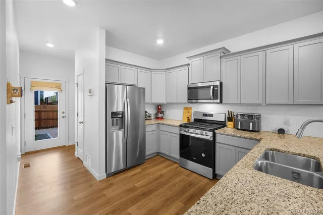 a kitchen with granite countertop a refrigerator and a sink