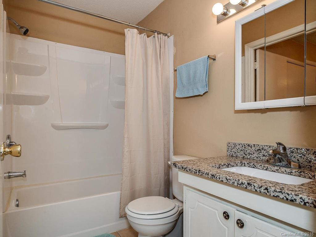 5825 Hunting Ridge Lane, Unit B Charlotte, NC 28212 - Photo 14 of 17 a bathroom with a granite countertop bathtub shower sink vanity and toilet