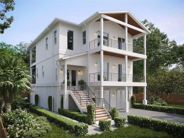 a view of a white house with large windows and a yard with plants and trees
