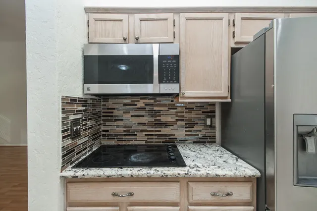 a kitchen with granite countertop a sink and a stove