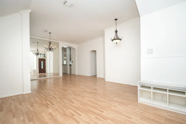 a view of empty room with wooden floor