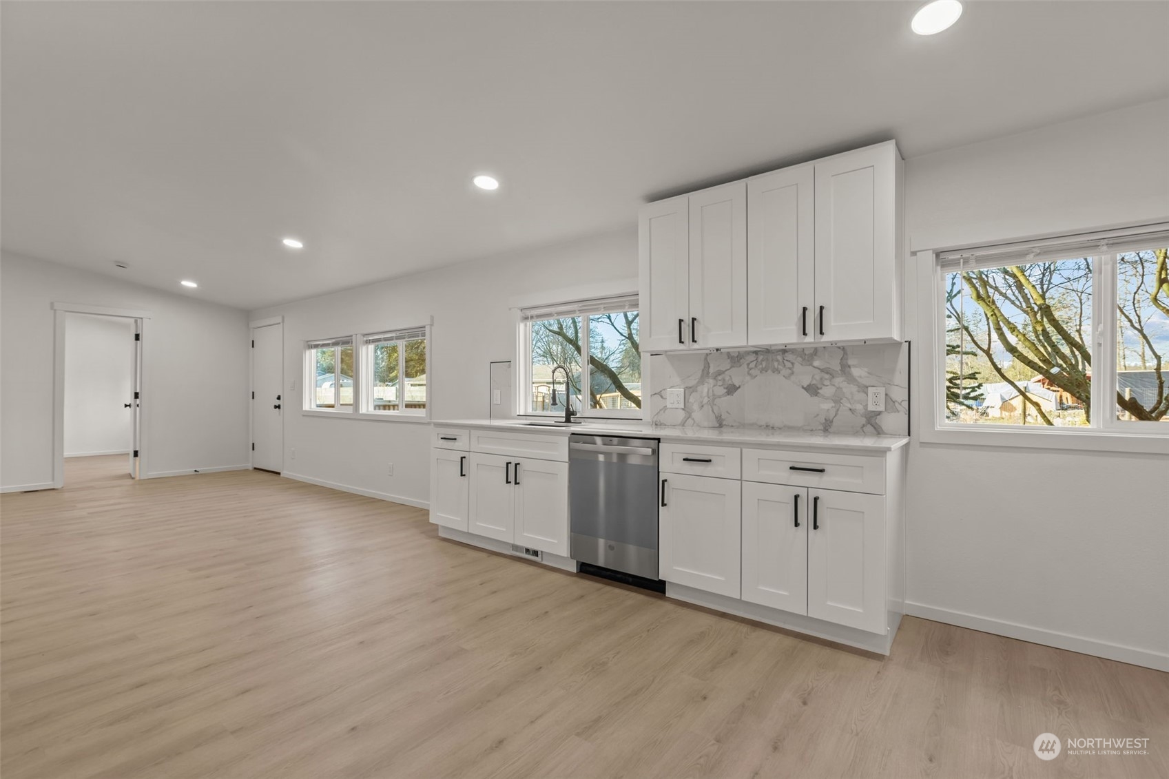 12017 Chappel Road Arlington, WA 98223 - Photo 40 of 40 a kitchen with granite countertop a stove a sink and white cabinets with wooden floor