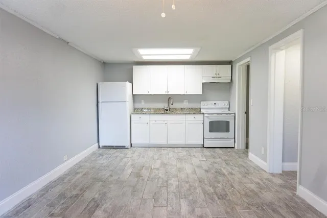 a kitchen with a refrigerator a sink and a stove top oven
