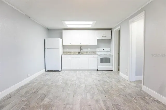 a view of a kitchen with a sink a refrigerator and window