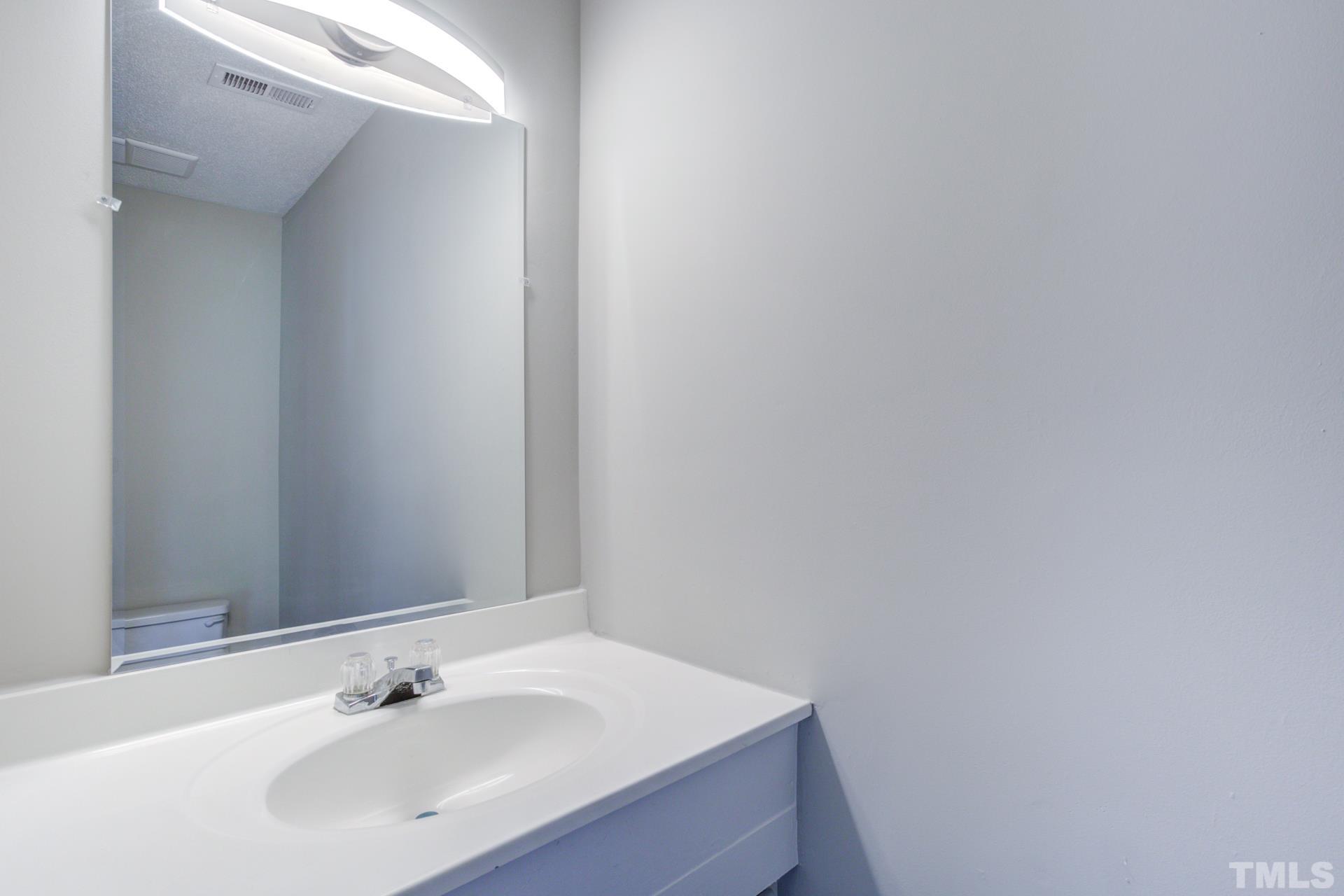 5062 Flint Ridge Place, Unit 5062 Raleigh, NC 27609 - Photo 18 of 23 a bathroom with a sink and a mirror