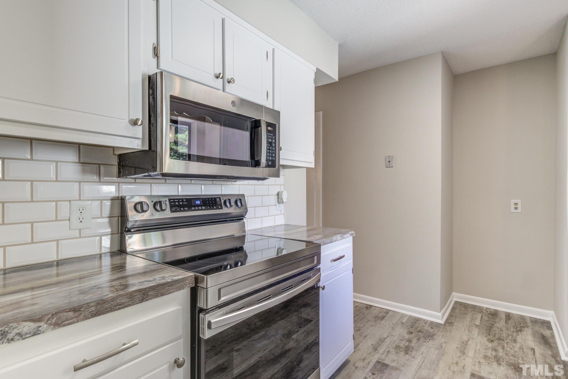 5062 Flint Ridge Place, Unit 5062 Raleigh, NC 27609 - Photo 4 of 23 a kitchen with a stove and a microwave