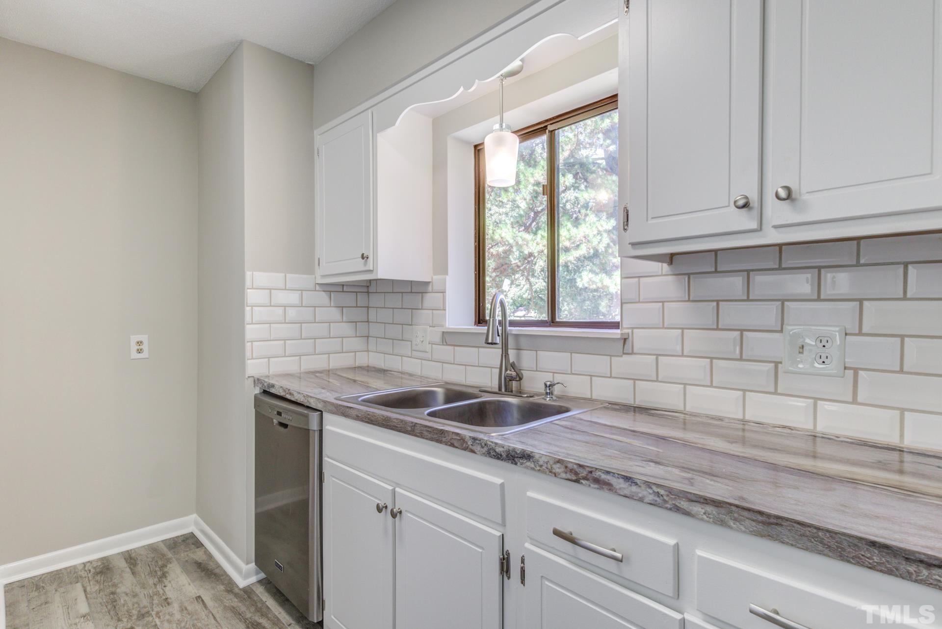 5062 Flint Ridge Place, Unit 5062 Raleigh, NC 27609 - Photo 5 of 23 a kitchen with granite countertop white cabinets and a sink