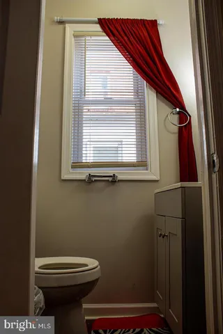 a bathroom with a toilet and a window