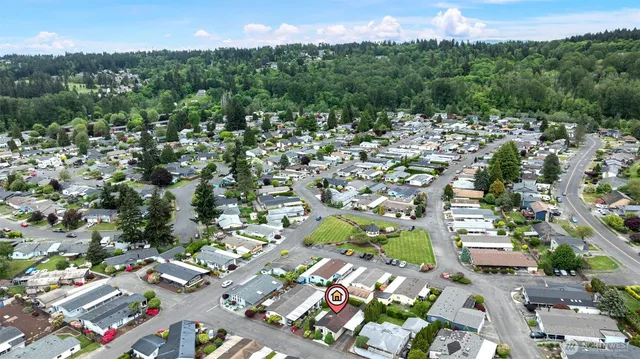 an aerial view of residential houses with outdoor space and trees