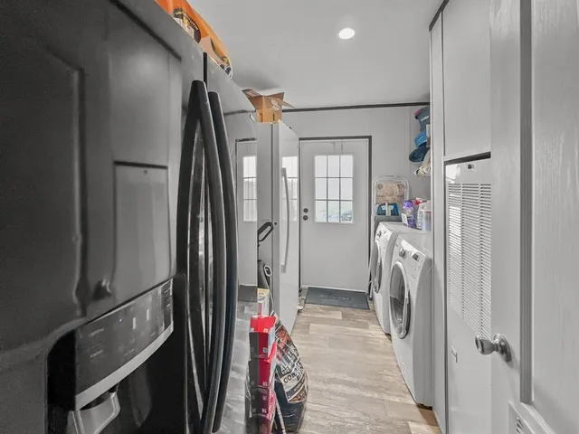 a walk in closet with wooden floor and a bathroom