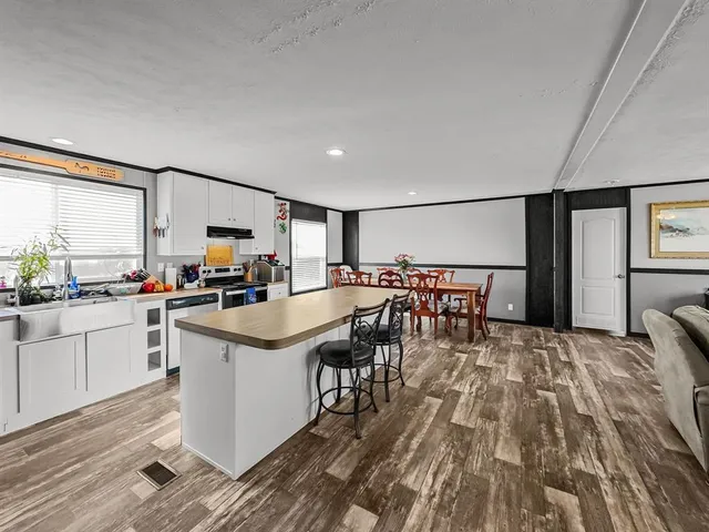 a open kitchen with stainless steel appliances granite countertop a stove and a refrigerator