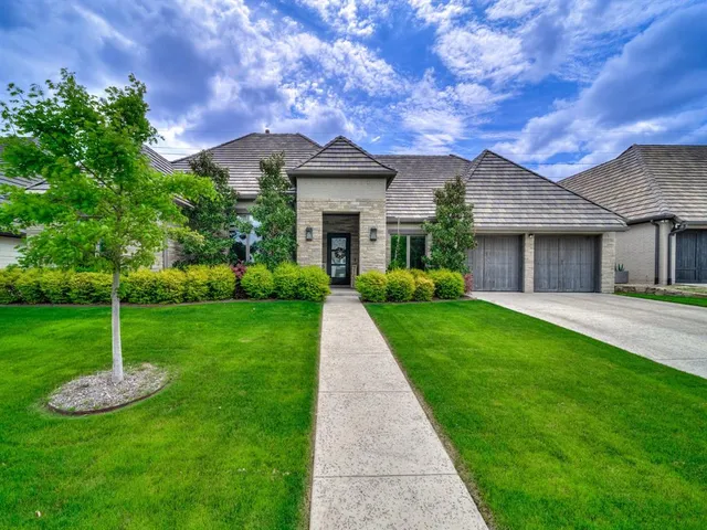 a front view of a house with a garden and yard