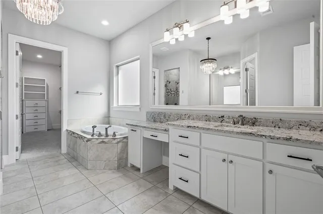 a bathroom with a granite countertop sink two mirror and a shower