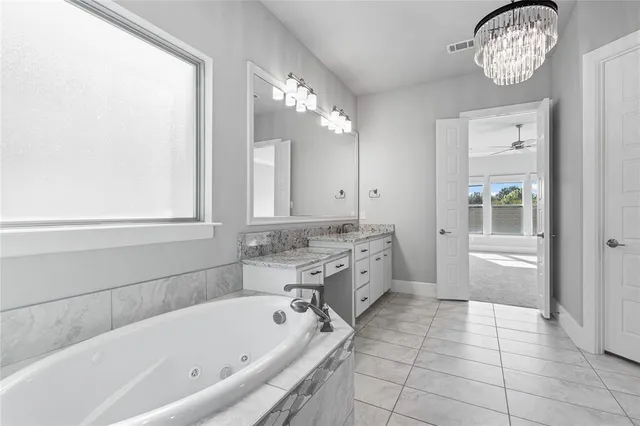 a view of an empty room with wooden floor and a kitchen