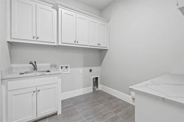 a kitchen with white cabinets and sink