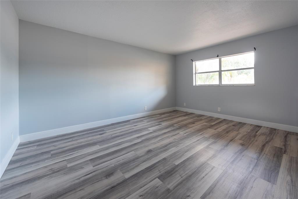 6061 North Falls Cir Drive, Unit 102 Lauderhill, FL 33319 - Photo 16 of 26 wooden floor in an empty room with a window