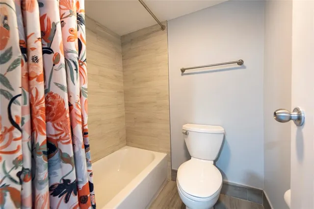 a white toilet sitting next to a bathroom sink and a shower