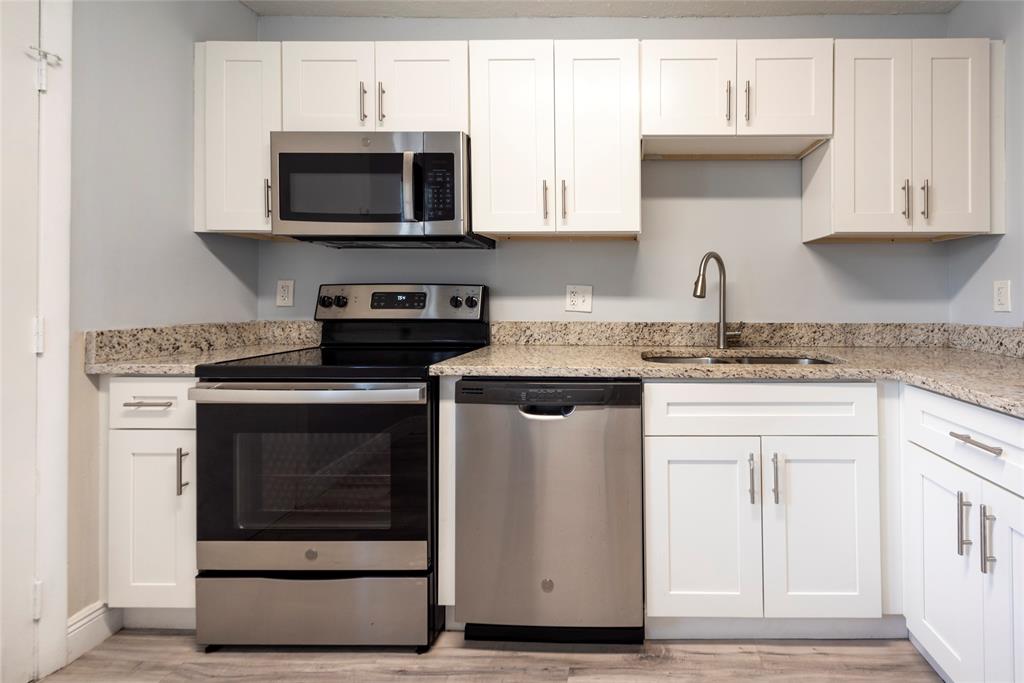 6061 North Falls Cir Drive, Unit 102 Lauderhill, FL 33319 - Photo 2 of 26 a kitchen with stainless steel appliances granite countertop a stove microwave and sink