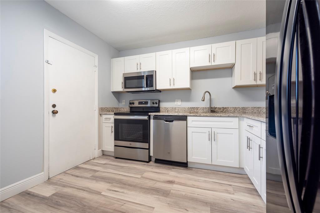 6061 North Falls Cir Drive, Unit 102 Lauderhill, FL 33319 - Photo 4 of 26 a kitchen with white cabinets and appliances