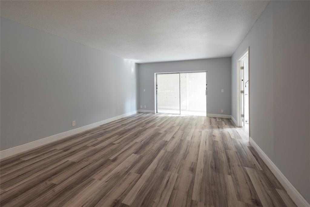 6061 North Falls Cir Drive, Unit 102 Lauderhill, FL 33319 - Photo 7 of 26 wooden floor in an empty room with a window