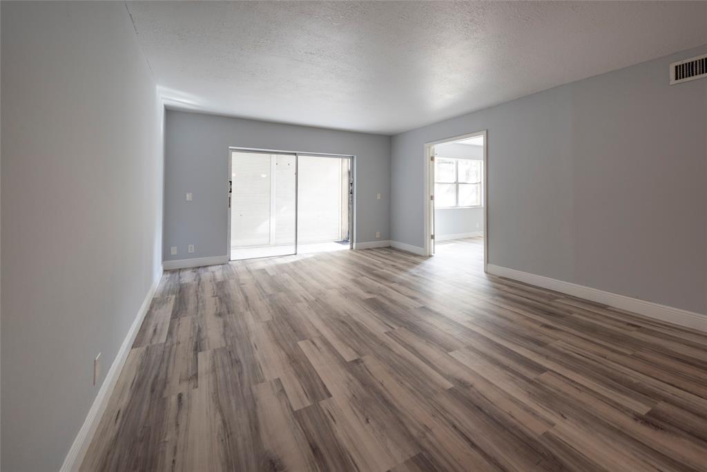 6061 North Falls Cir Drive, Unit 102 Lauderhill, FL 33319 - Photo 9 of 26 a view of an empty room with wooden floor and window