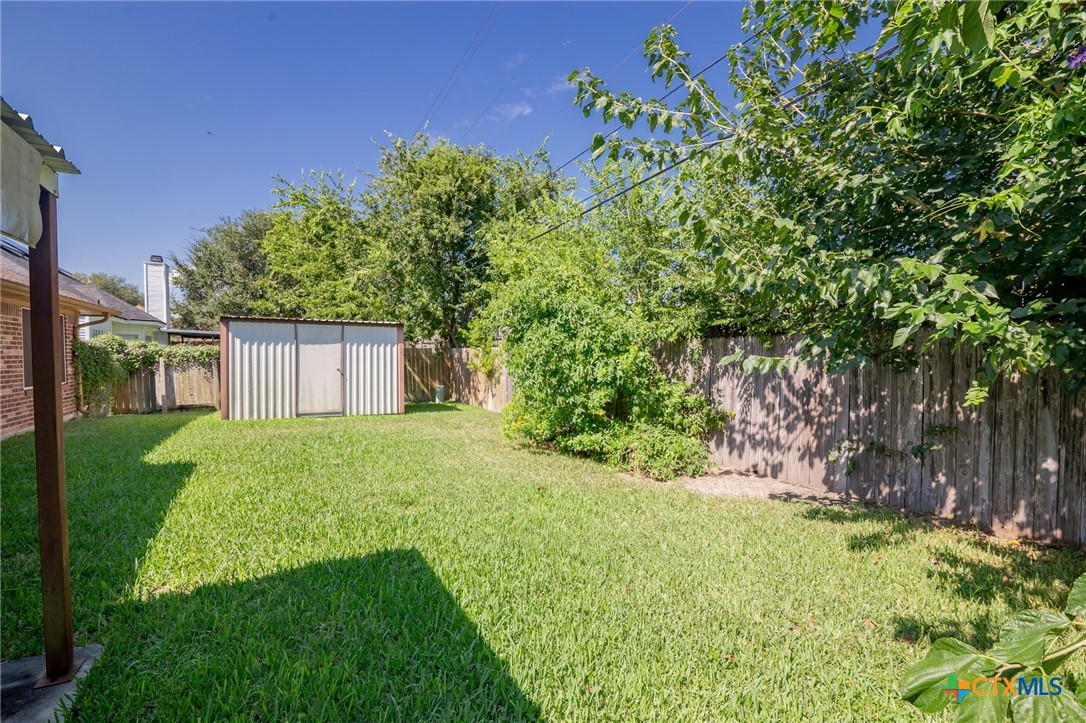 409 Newhaven Street Victoria, TX 77904 - Photo 28 of 28 a view of a back yard with an tree and a fence