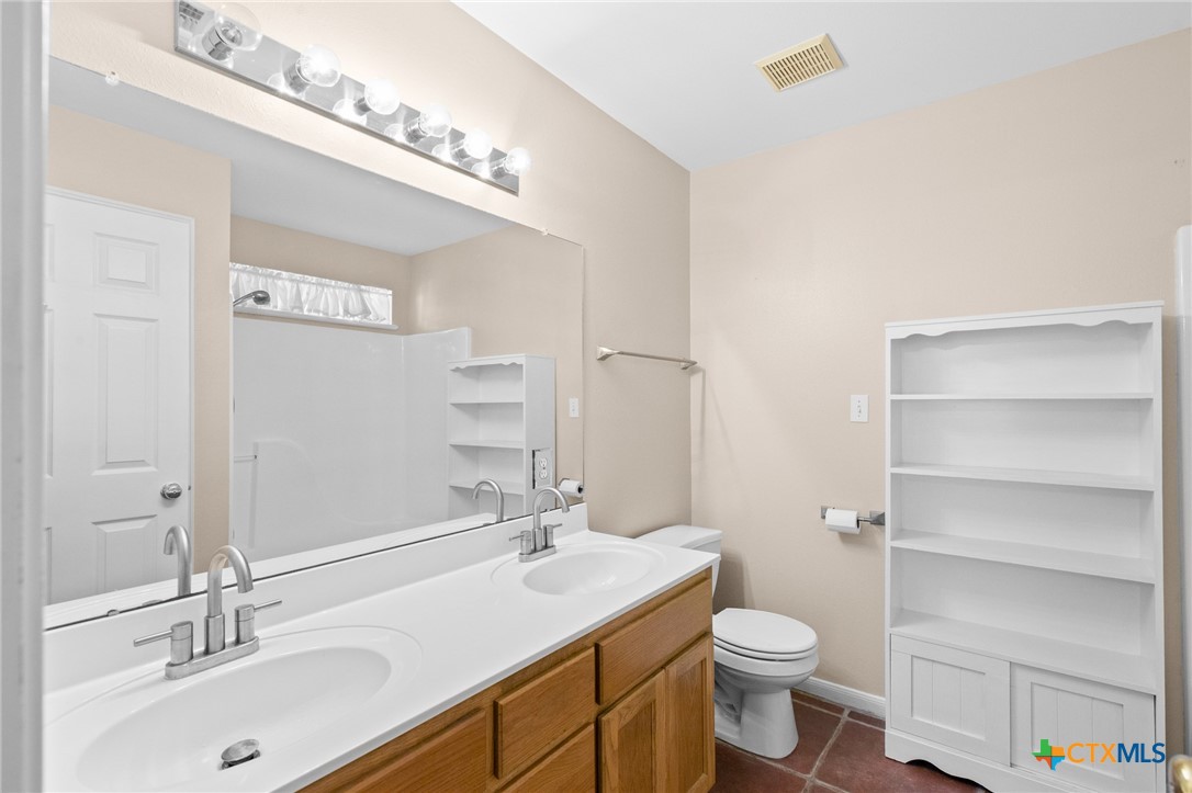 409 Newhaven Street Victoria, TX 77904 - Photo 4 of 28 a bathroom with a toilet a sink a mirror and vanity