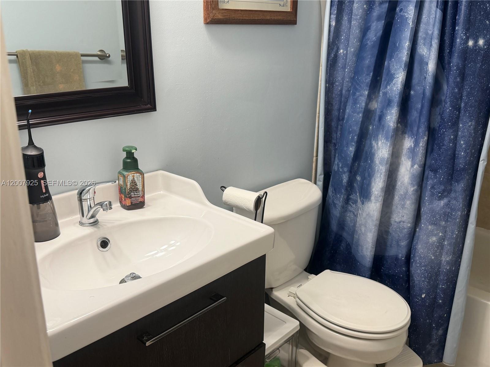 13541 Southwest 10th Place Davie, FL 33325 - Photo 14 of 20 a bathroom with a toilet a sink and a mirror