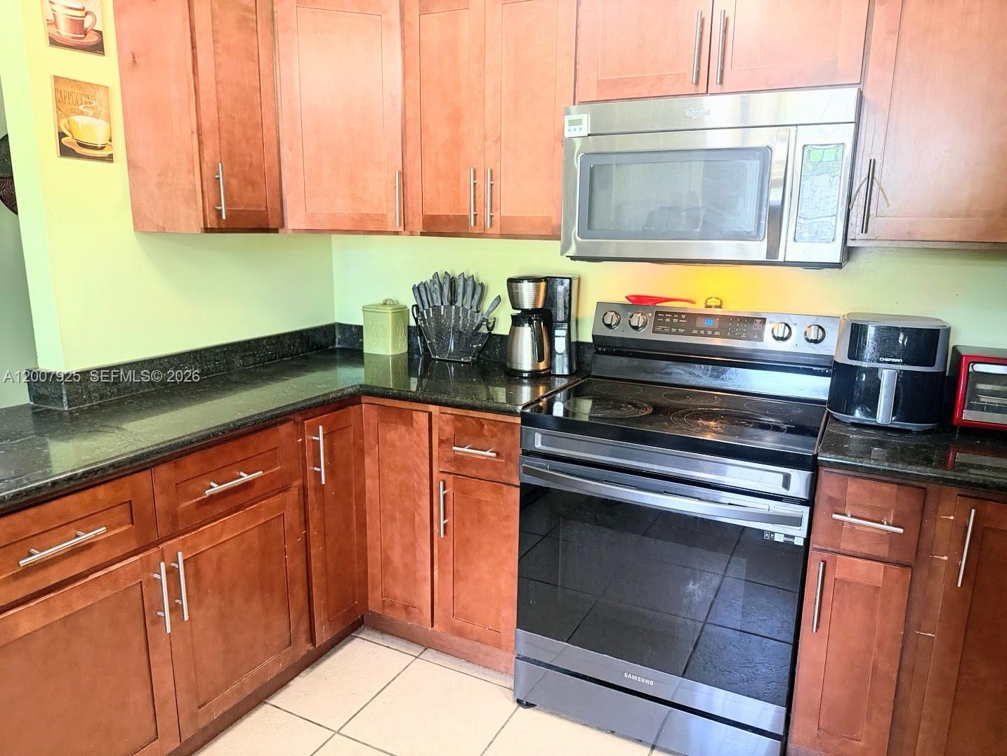 13541 Southwest 10th Place Davie, FL 33325 - Photo 4 of 20 a kitchen with granite countertop cabinets stainless steel appliances and a counter space