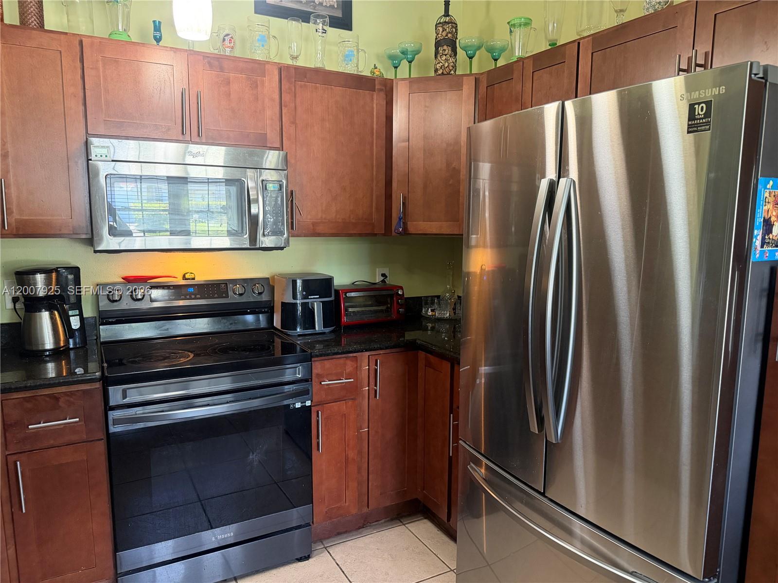 13541 Southwest 10th Place Davie, FL 33325 - Photo 5 of 20 a kitchen with a refrigerator sink and cabinets
