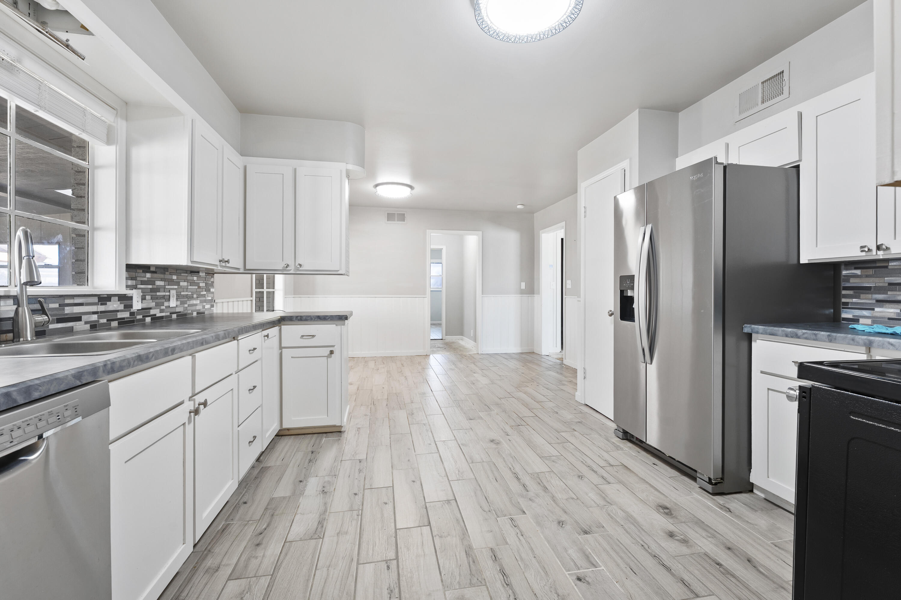 1201 8th Street Shallowater, TX 79363 - Photo 11 of 20 a kitchen with stainless steel appliances a refrigerator sink and wooden floor