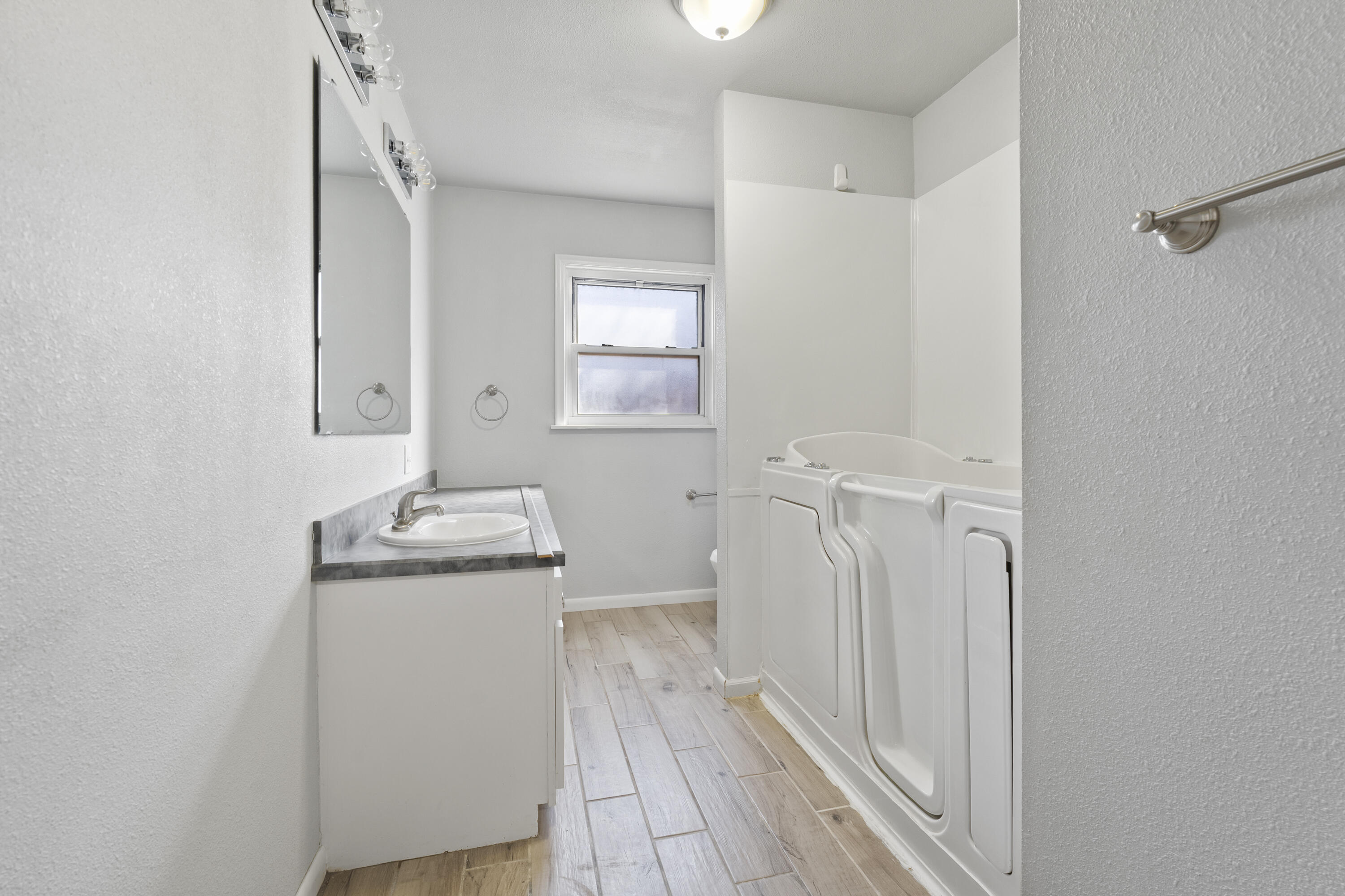 1201 8th Street Shallowater, TX 79363 - Photo 15 of 20 a bathroom with a granite countertop sink a toilet and a mirror