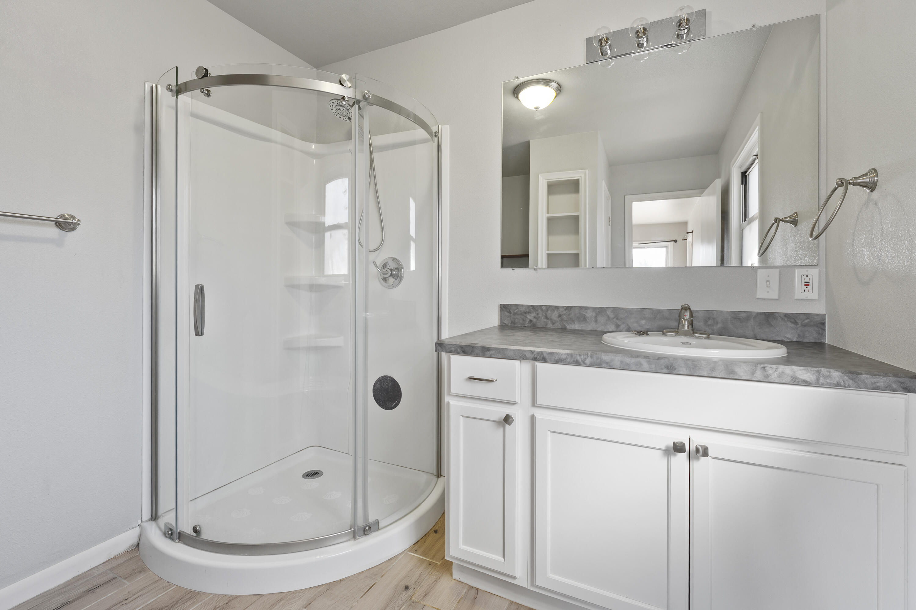 1201 8th Street Shallowater, TX 79363 - Photo 6 of 20 a bathroom with a granite countertop shower sink and mirror
