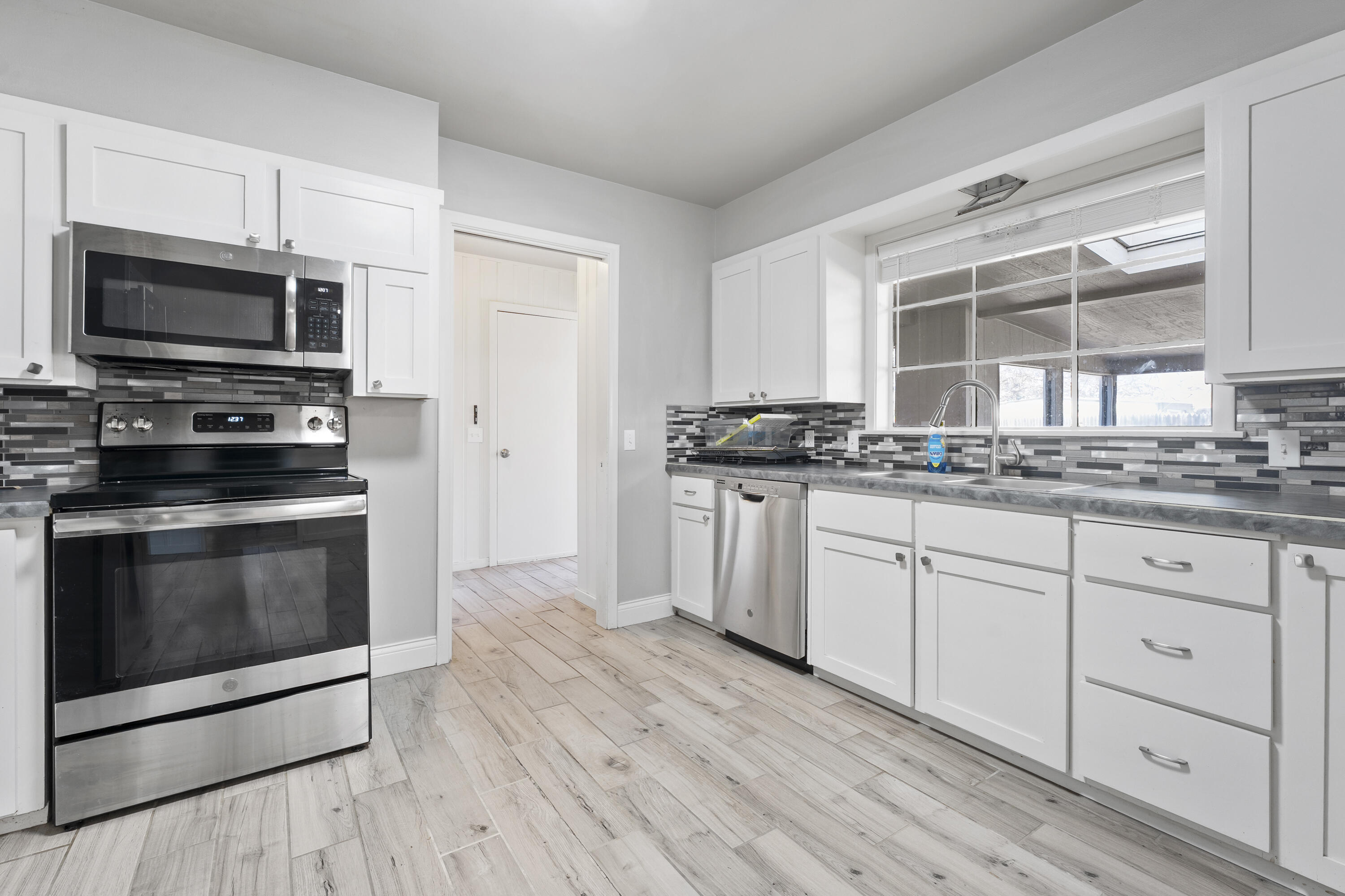 1201 8th Street Shallowater, TX 79363 - Photo 10 of 20 a kitchen with stainless steel appliances granite countertop a stove a sink and a microwave