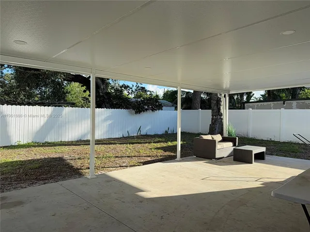 a backyard of a house with a yard and outdoor seating