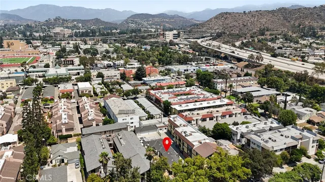 an aerial view of residential houses with outdoor space and trees