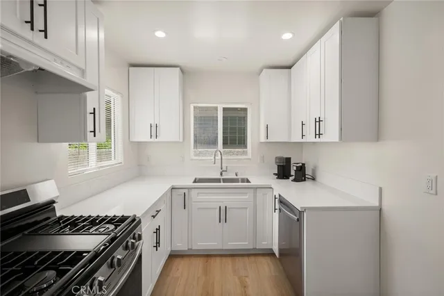 a kitchen with a sink stove top oven and cabinets