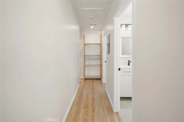 a view of a hallway with wooden floor and closet