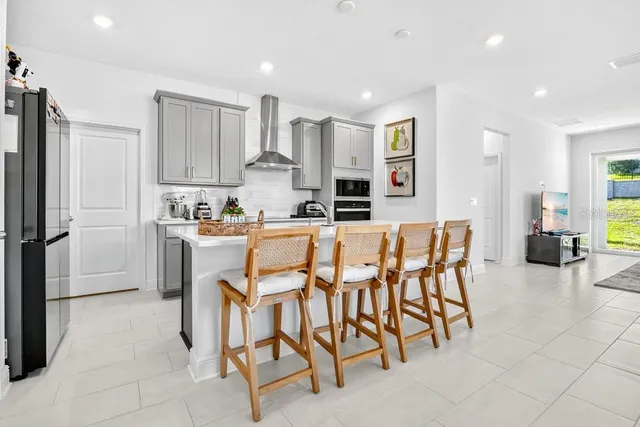 a kitchen with stainless steel appliances kitchen island granite countertop a refrigerator and microwave