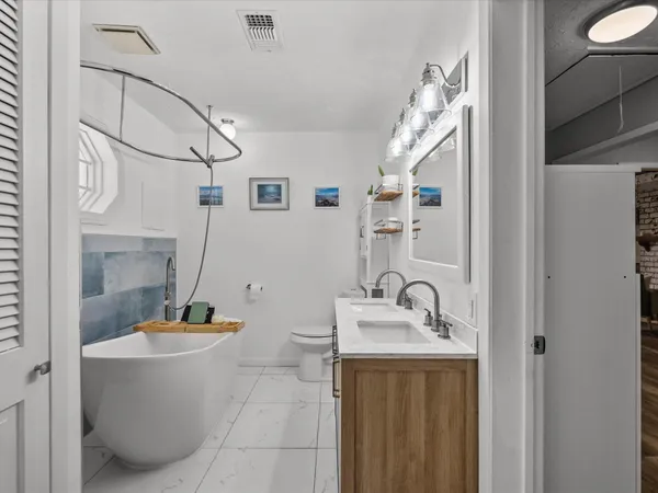 a bathroom with a sink a tub and a mirror