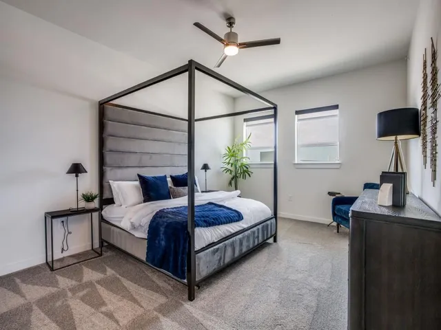 a bedroom with a bed and a lamp on the dresser