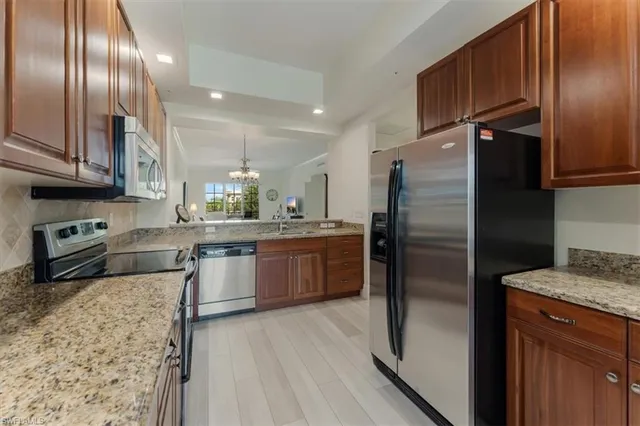 a kitchen with a refrigerator sink and wooden cabinets