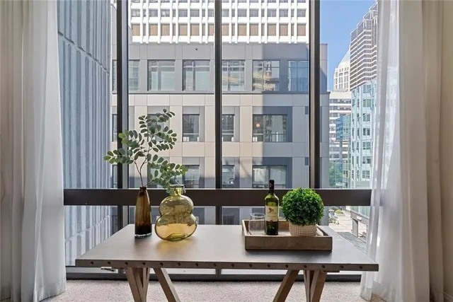 a view of a dining room and livingroom with furniture wooden floor a chandelier