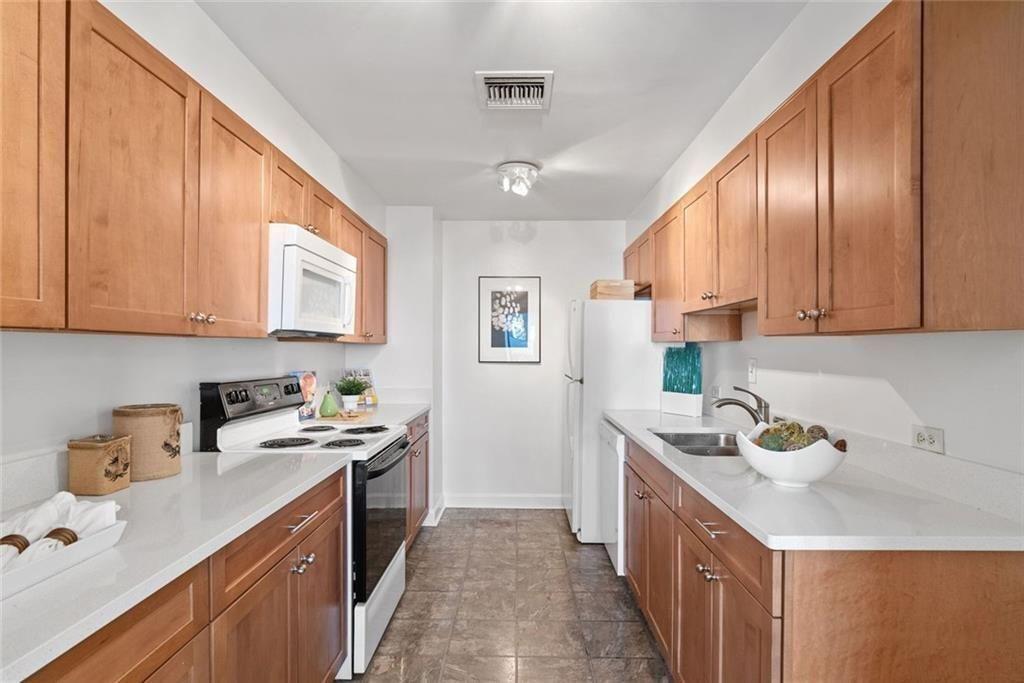 145 15th Street Northeast, Unit 602 Atlanta, GA 30361 - Photo 17 of 43 a kitchen with a sink stove top oven and cabinets