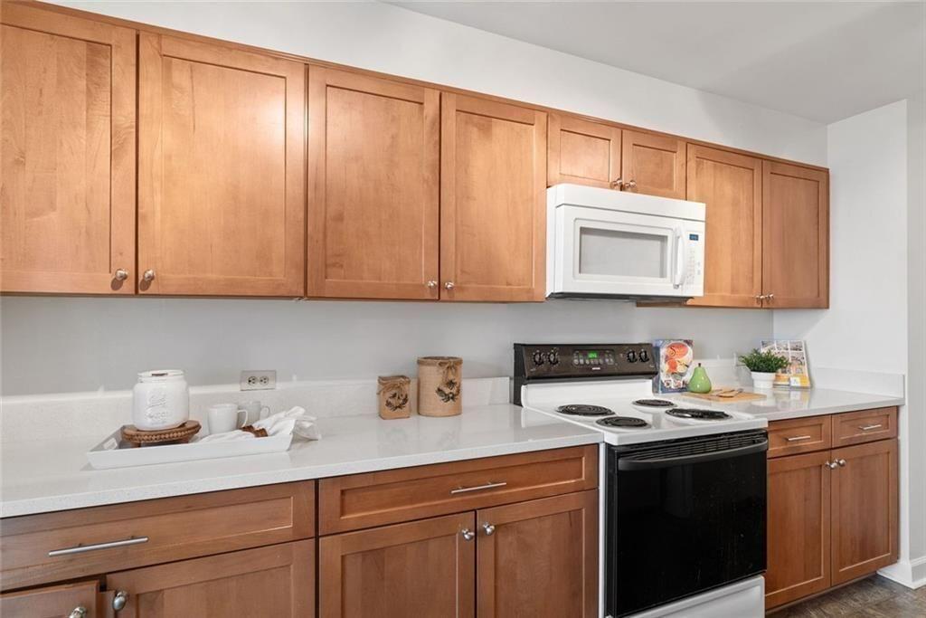 145 15th Street Northeast, Unit 602 Atlanta, GA 30361 - Photo 19 of 43 a kitchen with stainless steel appliances granite countertop white cabinets sink and dishwasher with wooden floor