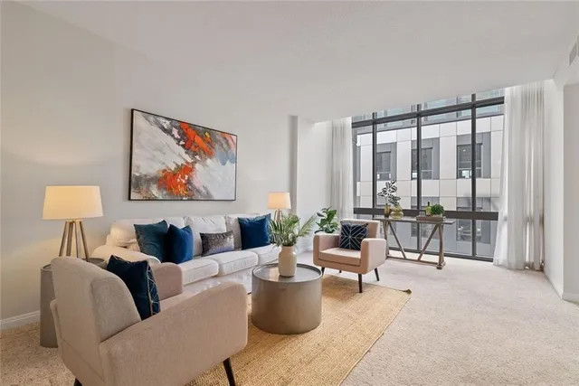 a living room with furniture and floor to ceiling window