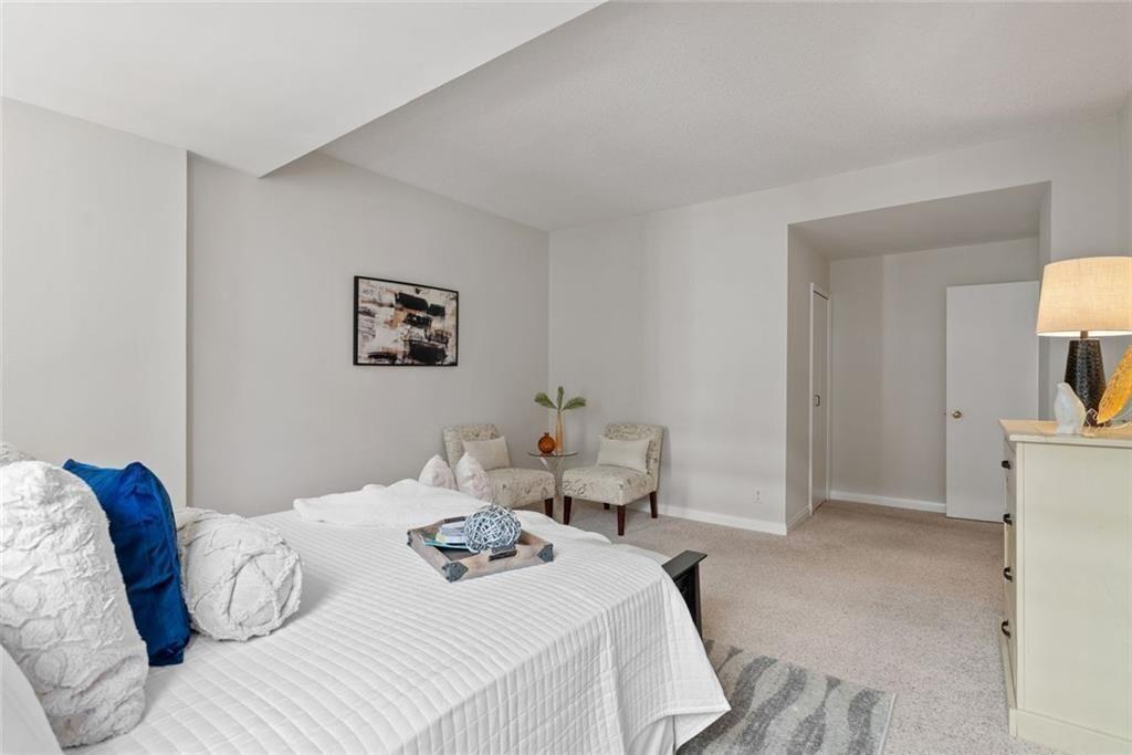 145 15th Street Northeast, Unit 602 Atlanta, GA 30361 - Photo 34 of 43 a bedroom with a bed and a lamp on dresser